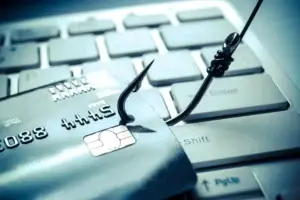 Laptop mit Warnung auf Monitor, Angelhaken und Kreditkarte, Schutz vor Phishing-Mails